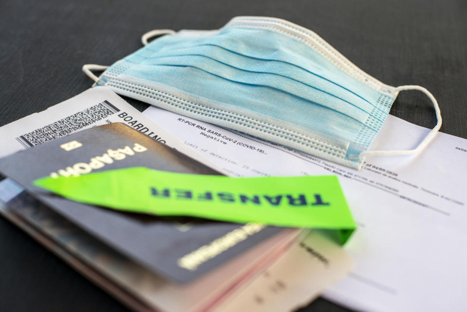 A passport, travel papers, and a face mask.