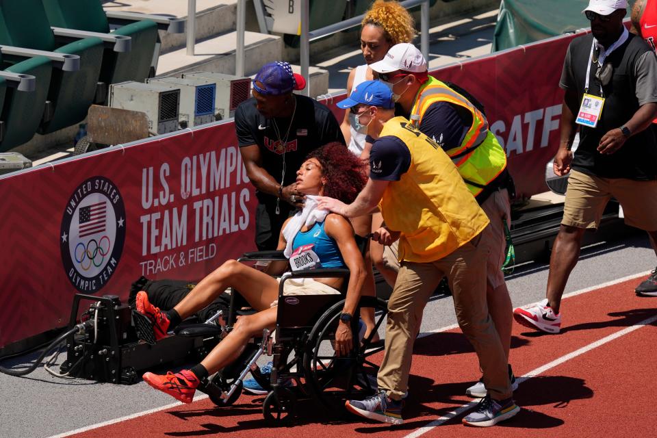 Taliyah Brooks is helped off track after collapsing during the heptathlon at the U.S. Olympic Track and Field Trials Sunday, June 27, 2021, in Eugene, Ore. Events were suspended due to high temperatures. (AP Photo/Charlie Riedel)