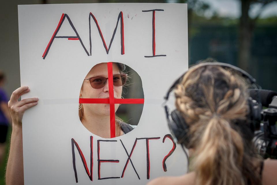 Emily Vogt of Pembroke Pines speaks to the media with her posterboard sign during a March for Our Lives event at Pine Trails Park in Parkland on Saturday.