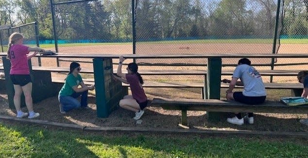 The Northridge National Honor Society spread mulch and painted dugouts and bleachers for its service project Monday at Parker Community Park in Alexandria.