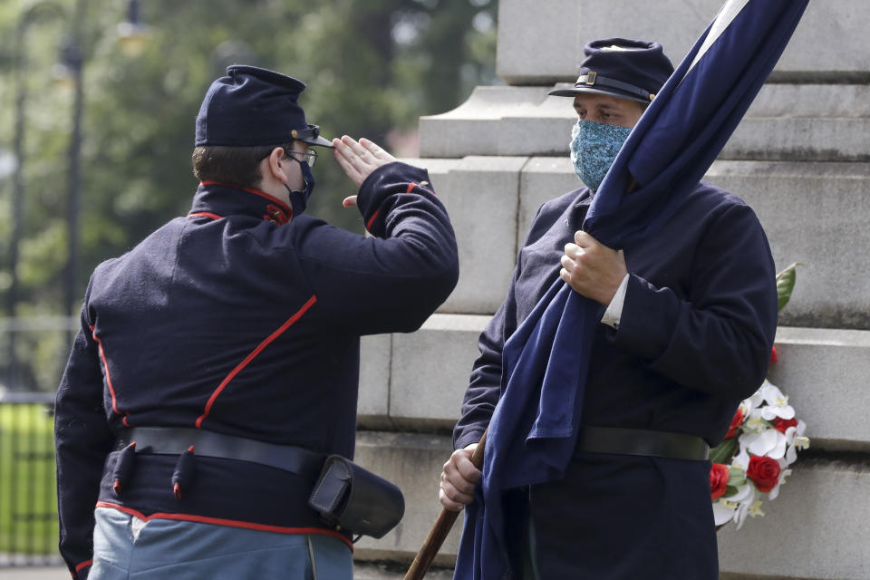 Demonstrators dressed in civil war attire participate in a flag ceremony in front of a Confederate statue at the Statehouse, Friday, July 10, 2020, in Columbia, S.C. Demonstrators gathered for the five year anniversary after the Confederate battle flag was removed from the Statehouse grounds after a two-thirds vote by the legislature. (AP Photo/Chris Carlson)