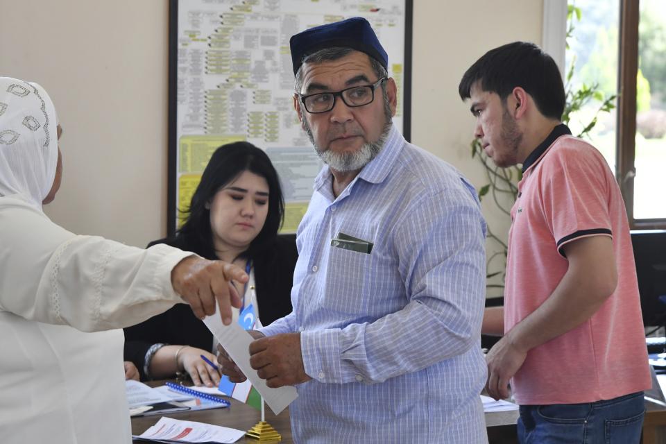 A man gets his ballot at a polling station during a referendum in Tashkent, Uzbekistan, Sunday, April 30, 2023. Voters in Uzbekistan are casting ballots in a referendum on a revised constitution that promises human rights reforms. But the reforms being voted on Sunday also would allow the country's president to stay in office until 2040. (AP Photo)