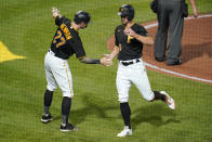 Pittsburgh Pirates' Kevin Newman (27) and Bryan Reynolds (10) celebrate after scoring on a single by Yoshi Tsutsugo and a throwing error by Cincinnati Reds centerfielder Aristides Aquino during the fifth inning of a baseball game in Pittsburgh, Tuesday, Sept. 14, 2021. (AP Photo/Gene J. Puskar)