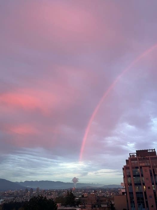 City skyline with a rainbow and sunset clouds