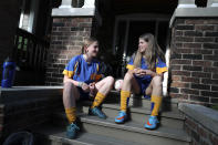 Ruby Wood, left, and her twin sister, Lola, talk on their home stoop in Toronto, Canada, on Monday, July 12, 2021. With Lola's aversion to needles, their mother told her: If you get the vaccine you’ll be able to see your friends again. You’ll be able to play sports. And enticed by the promise of resuming a normal, teen life, Lola agreed. (AP Photo/Kamran Jebreili)