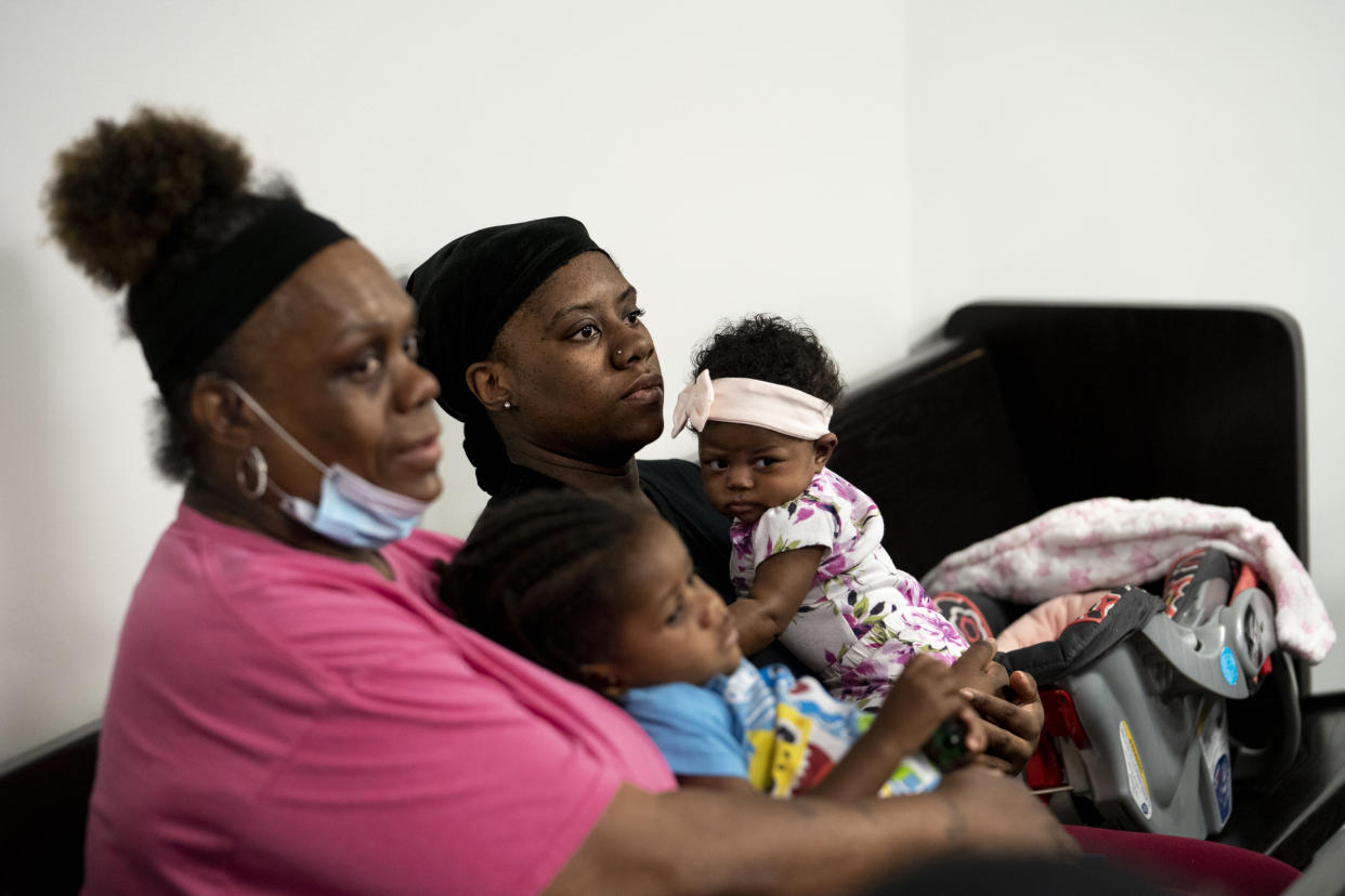 Brittany Jennings holds her two-month old daughter Si'Yere Jackson while waiting with her mom, Helen Jennings, who's holding Brittany's son Cincere Jackson, 2, at housing court in the 36th District Court in Detroit, Mich., on June 5, 2023. (Sarah Rice for NBC News)