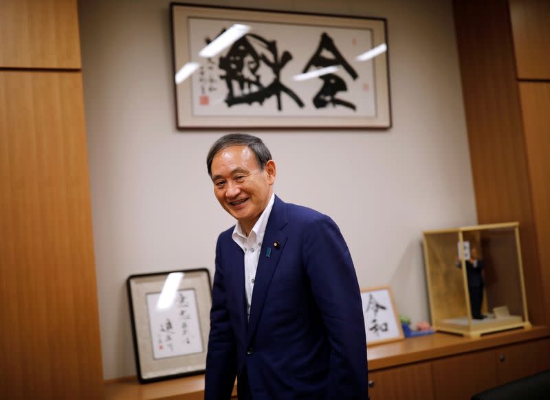 Japan's top government spokesman Chief Cabinet Secretary Yoshihide Suga smiles during an interview with Reuters in Tokyo