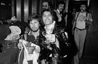 <p>Queen holds up the Toronto Maple Leaf jerseys they were gifted while performing in Canada in 1977. </p>