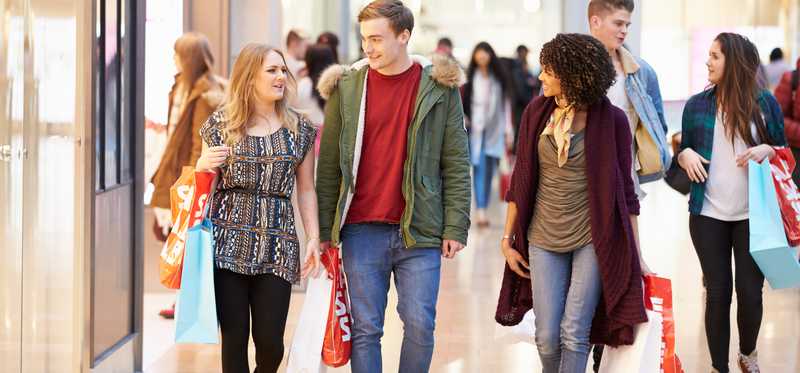 Three young friends shopping in a mall.