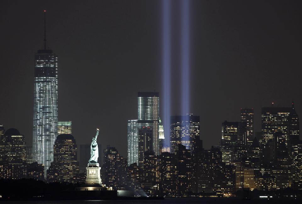 The Tribute in Light is illuminated next to the Statue of Liberty (C) and One World Trade Center (L) during events marking the 12th anniversary of the 9/11 attacks on the World Trade Center in New York, September 10, 2013. (REUTERS/Gary Hershorn)