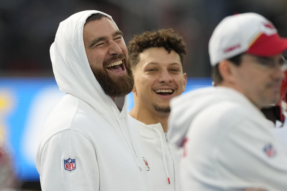 Kansas City Chiefs tight end Travis Kelce, left, jokes with quarterback Patrick Mahomes, center, and other teammates before an NFL football game against the Los Angeles Chargers, Sunday, Jan. 7, 2024, in Inglewood, Calif. (AP Photo/Ashley Landis)
