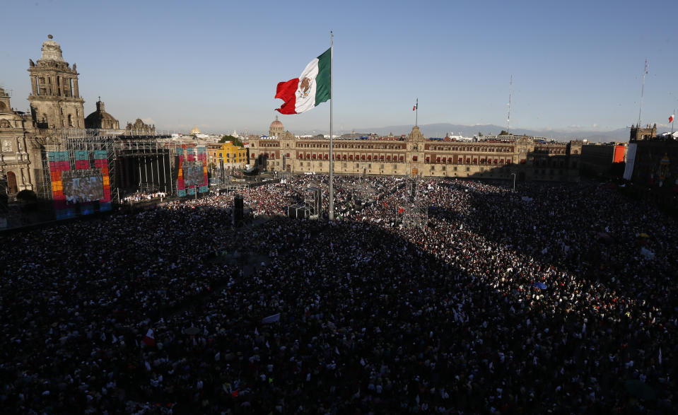 Flanked by the Metropolitan Cathedral, left, and the National Palace, people gather in the Zocalo to celebrate the country's newly sworn-in president, Andres Manuel Lopez Obrador, in Mexico City, on Saturday, Dec. 1, 2018. The inauguration of Lopez Obrador marked a turning point in one of the world's most radical experiments in opening markets and privatization. (AP Photo/Marco Ugarte)