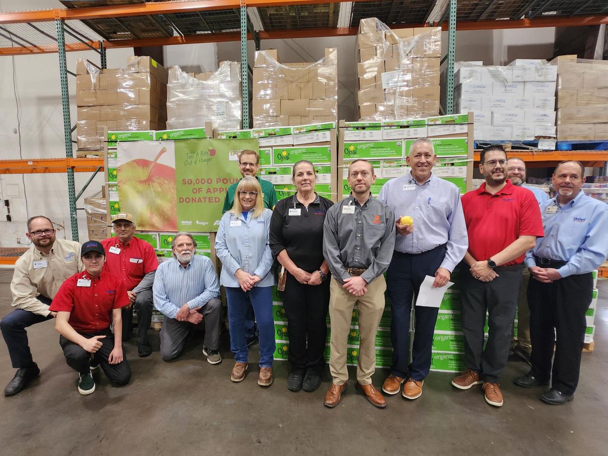 United Family representatives and members of the High Plains Food Bank pose in front of over 2,000 apples donated to the food bank Wednesday morning.