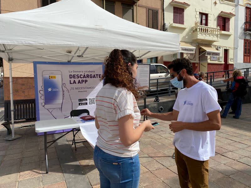 Volunteers show residents how to install an app to trace contacts with people potentially infected with the coronavirus disease (COVID-19) being trialled on the Canary Island of La Gomera