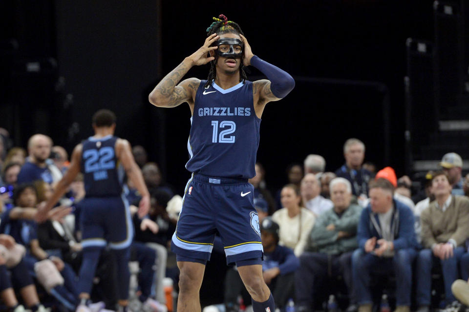 Memphis Grizzlies guard Ja Morant (12) adjusts his face guard in the second half of an NBA basketball game against the Houston Rockets Wednesday, March 22, 2023, in Memphis, Tenn. (AP Photo/Brandon Dill)