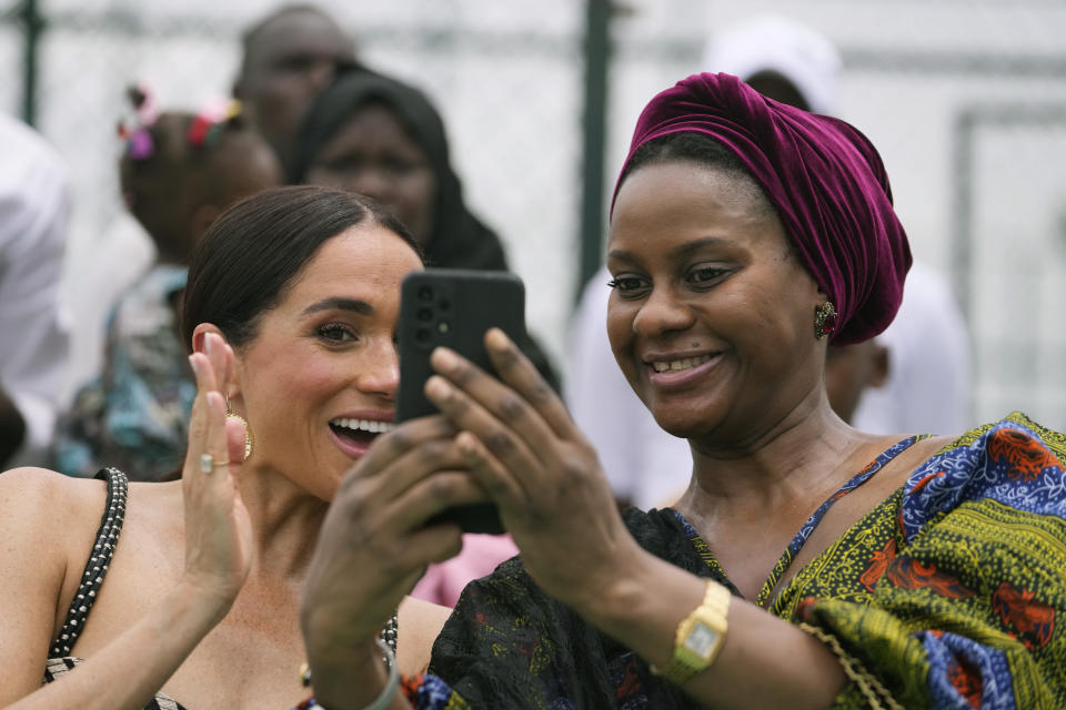 Meghan Markle, left, and an unidentified woman take a selfie during an exhibition sitting volleyball match in Abuja, Nigeria, Saturday, May 11, 2024. Prince Harry and his wife Meghan are in Nigeria to champion the Invictus Games, which he founded to aid the rehabilitation of wounded and sick service members and veterans. (AP Photo/Sunday Alamba)