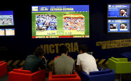 Customers prepare their sporting bets at the betting shop Victoria in Madrid in this October 11, 2008 file photo. REUTERS/Susana Vera/Files