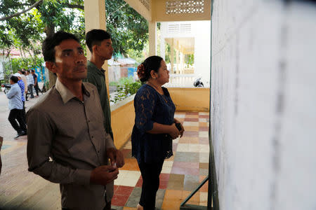 Voters look at a voters list before the start of a general election in Takhmao, Kandal province, Cambodia July 29, 2018. REUTERS/Darren Whiteside