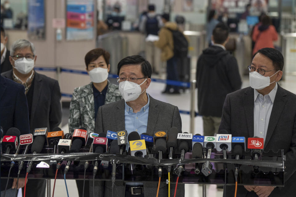 Hong Kong Chief Executive John Lee, center, wearing a face mask speaks to the media after he inspected Lok Ma Chau station following the reopening of crossing border with mainland China, in Hong Kong, Sunday, Jan. 8, 2023. Travelers crossing between Hong Kong and mainland China, however, are still required to show a negative COVID-19 test taken within the last 48 hours, a measure China has protested when imposed by other countries. (AP Photo/Bertha Wang)