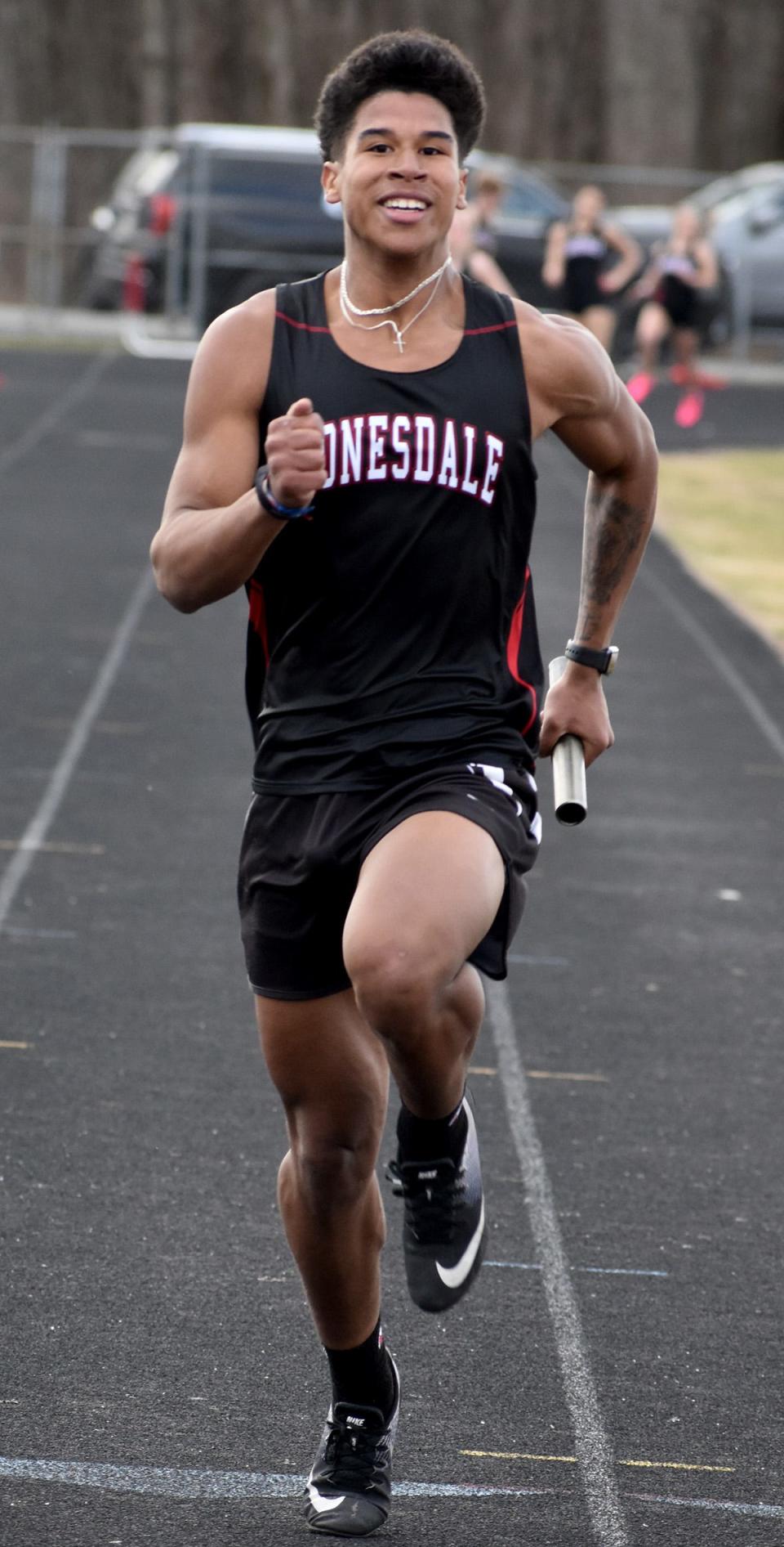 Jeffy Delgado-Santos of Honesdale is all smiles while cruising toward the finish line anchoring the 400M relay.