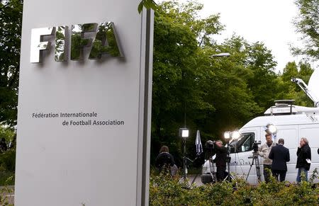 Members of the media stand in front of the entrance of the Federation Internationale de Football Association (FIFA) headquarters in Zurich, Switzerland, May 30, 2015. REUTERS/Arnd Wiegmann