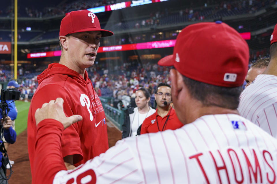 Philadelphia Phillies' Kyle Gibson, left, is congratulated by manager Rob Thomson, right, following the ninth inning of a baseball game against the Washington Nationals, Friday, Aug. 5, 2022, in Philadelphia. (AP Photo/Chris Szagola)