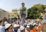 Supporters of Islami Andolan Bangladesh, an Islamist political party, carry a cutout of French President Emmanuel Macron with a garland of footwear around it as they protest against the publishing of caricatures of the Prophet Muhammad they deem blasphemous, in Dhaka, Bangladesh, Tuesday, Oct. 27, 2020. Muslims in the Middle East and beyond on Monday called for boycotts of French products and for protests over the caricatures, but Macron has vowed his country will not back down from its secular ideals and defense of free speech. (AP Photo/Mahmud Hossain Opu)