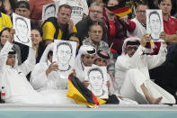 Spectators hold photos of Forman German international Mesut Ozil on the stands during the World Cup group E soccer match between Spain and Germany, at the Al Bayt Stadium in Al Khor , Qatar, Sunday, Nov. 27, 2022. (AP Photo/Matthias Schrader)