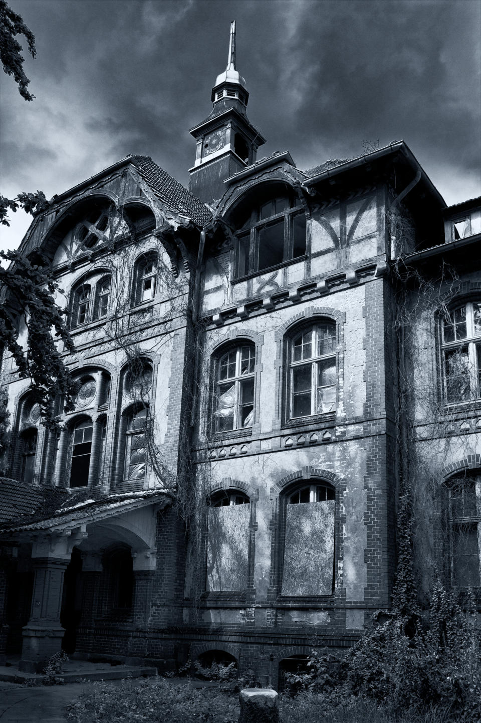 Old abandoned house with creeping vines and a spire