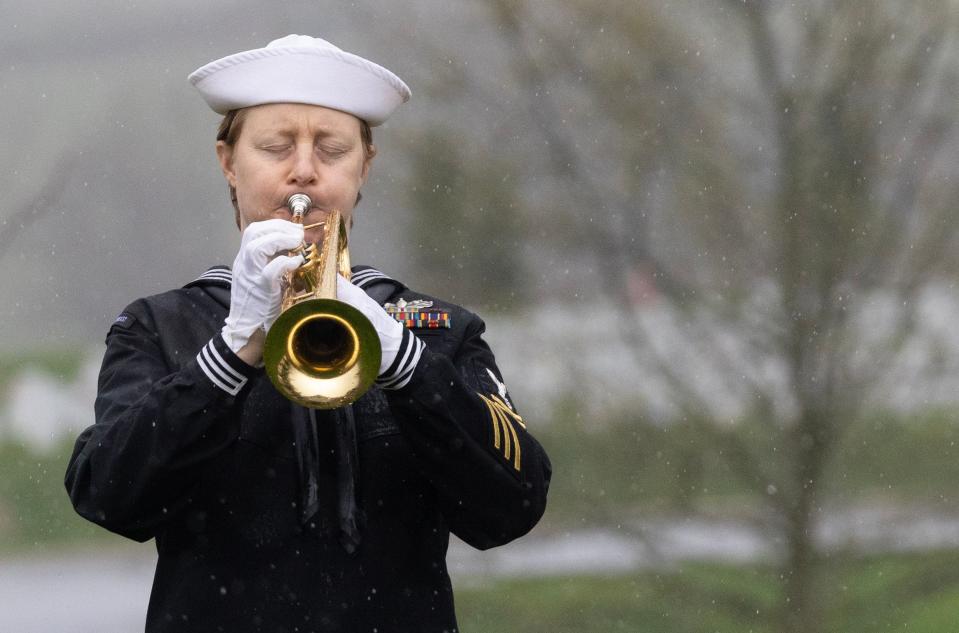 U.S. Navy Musician 1st Class Catherine Chauvot plays taps Thursday at the funeral service for Fireman 1st Class Walter Schleiter, of Massillon.