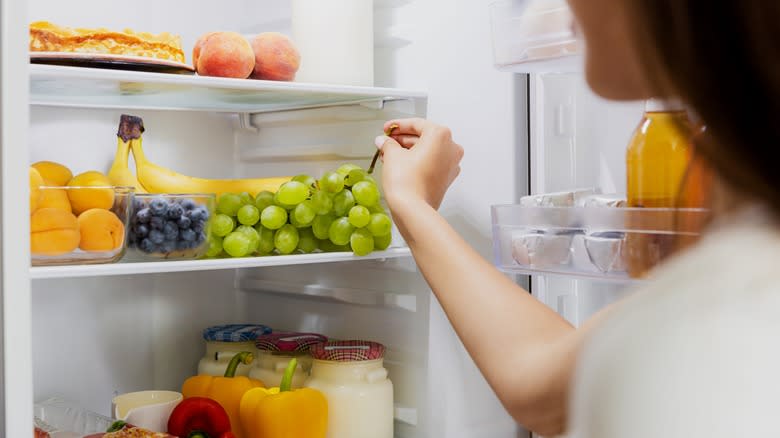 Person taking fruit from refrigerator