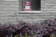 In this Sunday, March 29, 2020, photo, a teddy bear sits in a window of a house in Christchurch, New Zealand. New Zealanders are embracing an international movement in which people are placing teddy bears in their windows during coronavirus lockdowns to brighten the mood and give children a game to play by spotting the bears in their neighborhoods. (AP Photo/Mark Baker)