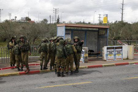 Israeli soldiers gather near the scene where the Israeli military said two Palestinians stabbed and wounded an Israeli woman and were then shot and killed outside the Jewish settlement of Ariel in the occupied West Bank March 17, 2016. REUTERS/Baz Ratner