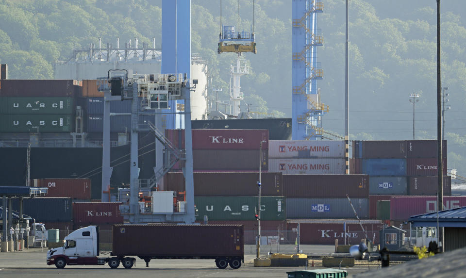 A truck drives near cargo containers, Friday, May 10, 2019, at the Port of Tacoma in Tacoma, Wash. U.S. and Chinese negotiators resumed trade talks Friday under increasing pressure after President Donald Trump raised tariffs on $200 billion in Chinese goods and Beijing promised to retaliate. (AP Photo/Ted S. Warren)