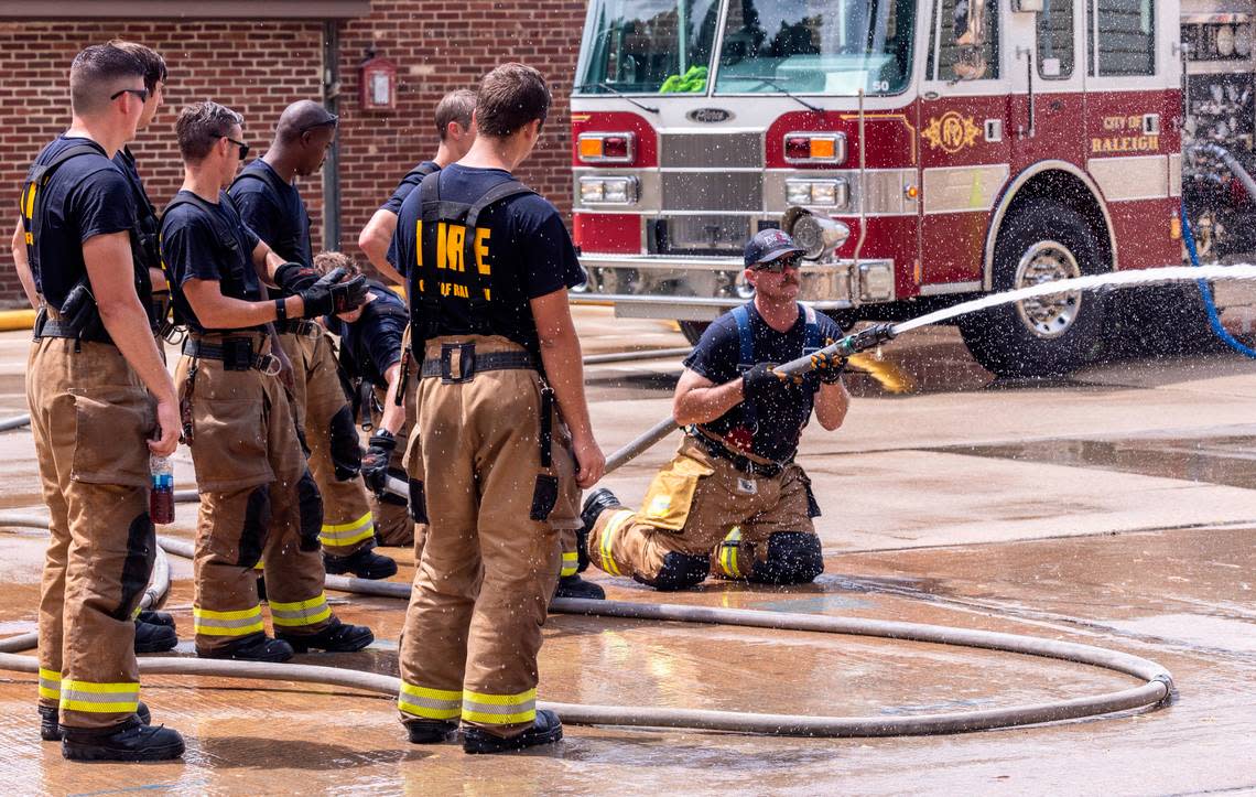 Captain Greg Wheeler of the Raleigh Fire Department, kneeling, leads a demonstration for Raleigh firefighter recruits at the Keeter Training Center in Raleigh Monday, July 25, 2022. The Raleigh Fire Department has 65 vacancies and a current academy class with 55 graduates expected this fall.