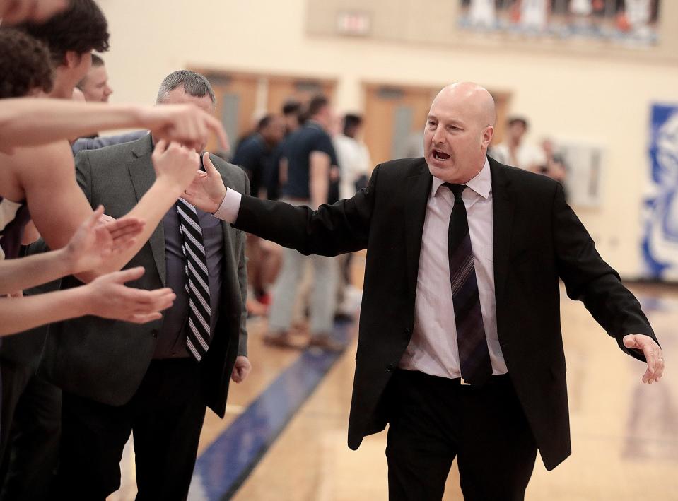 Jackson High’s boys varsity basketball coach Tim Debevec celebrates with the bench as the final seconds tick off the clock of their win over Solon in their district semifinal game at Twinsburg High School Wednesday, March 2, 2022. 