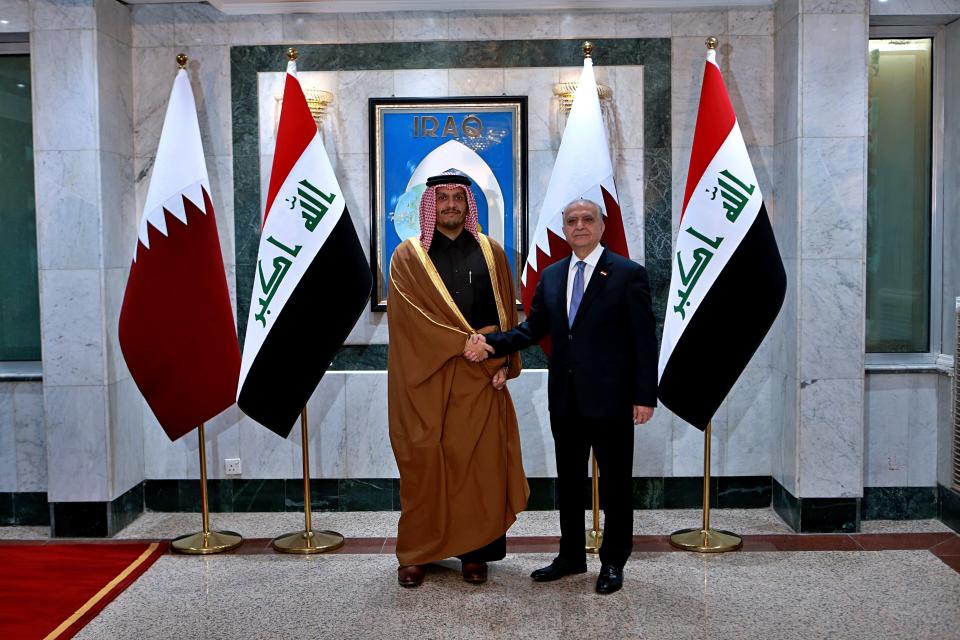 Iraqi Foreign Minister Mohamed Alhahkim, right, shakes hands with visiting Qatari counterpart Sheikh Mohammed bin Abdulrahman Al Thani in Baghdad, Iraq, Wednesday, Jan. 15, 2020. (AP Photo/Khalid Mohammed)