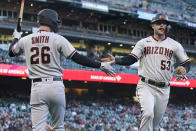 Arizona Diamondbacks' Christian Walker (53) is congratulated by teammate Pavin Smith (26) after scoring against the San Francisco Giants during the fourth inning of a baseball game in San Francisco, Monday, June 14, 2021. (AP Photo/Jeff Chiu)