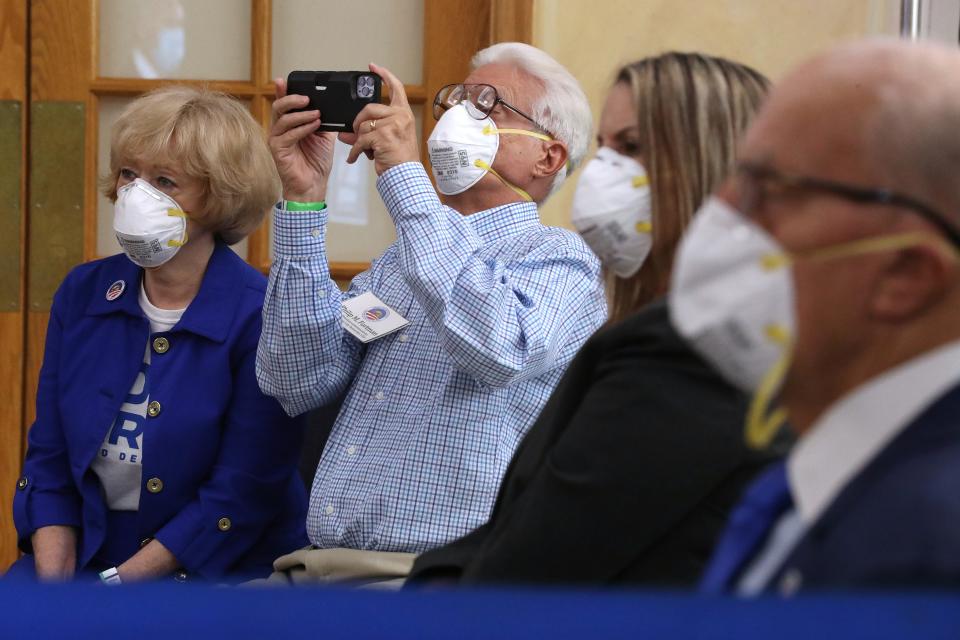 Philip Fortman (2nd-L) makes a photograph as he and his wife Karen Fortman listen to Democratic presidential nominee Joe Biden deliver remarks about his ‘vision for older Americans’ at Southwest Focal Point Community Center October 13, 2020 in Pembroke Pines, Florida.