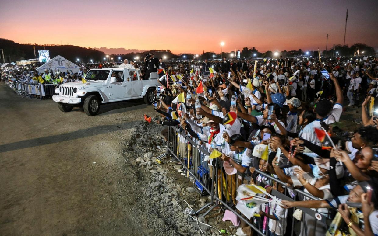 Members of the crowd attempt to take pictures of Pope Francis on their mobile phones