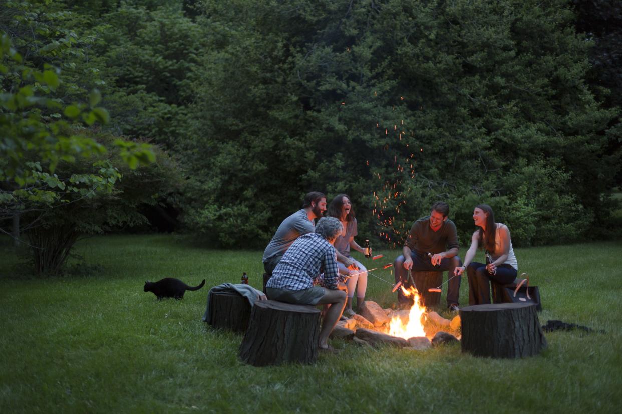 Group of adults around a fire pit, Brampton Inn, Chestertown, Maryland, USA. (Photo by: Jumping Rocks/Universal Images Group via Getty Images)