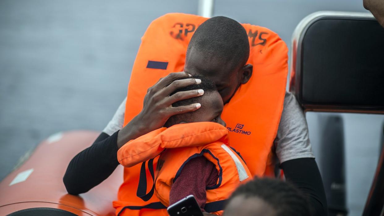 Ein Mann hält seinen Sohn im Arm, nachdem er gemeinsam mit anderen Flüchtlingen gerettet wurde.