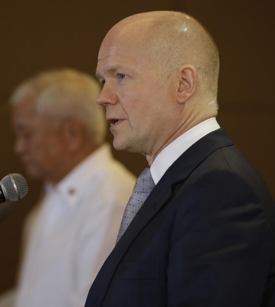 British Foreign Secretary William Hague answers questions from the media during a joint news conference with his Philippine counterpart Albert del Rosario, left, Thursday, Jan. 30, 2014 in Manila, Philippines. Hague said the United Kingdom will take in some refugees from the Syrian conflict to "give them some respite and some care after some of the things that they have been through." (AP Photo/Bullit Marquez)