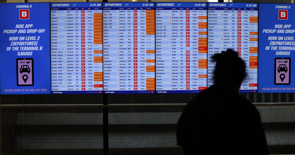 Boston, MA - January 11: A traveler surveys the departure board at Logan Airport. (Photo by David L. Ryan/The Boston Globe via Getty Images)