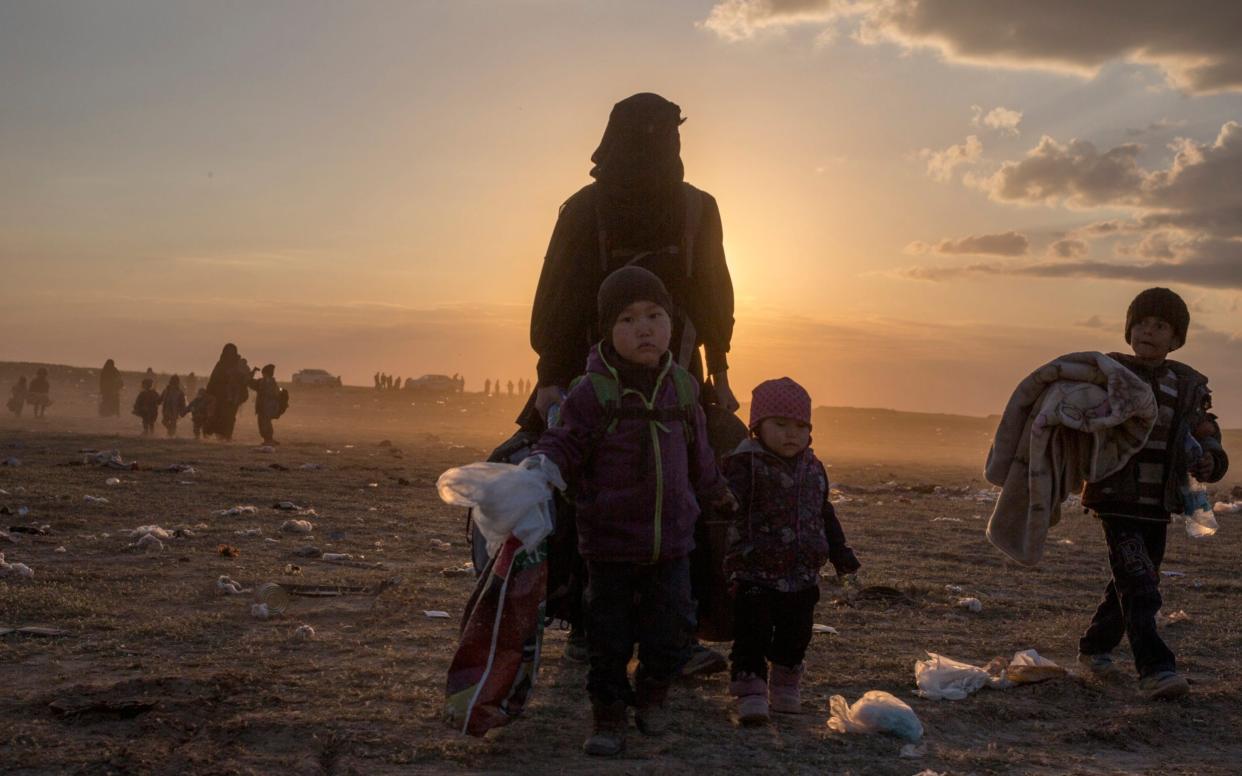 Civilians fleeing from Isil's last remaining territory in Syria arrive at a gathering point before being taken to an internment camp, near Baghuz, in north eastern Syria, on March 6, 2019. - The Telegraph