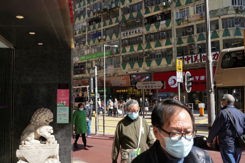 FILE PHOTO: People wearing face masks to prevent the spread of the coronavirus disease (COVID-19), walk on a street in Hong Kong