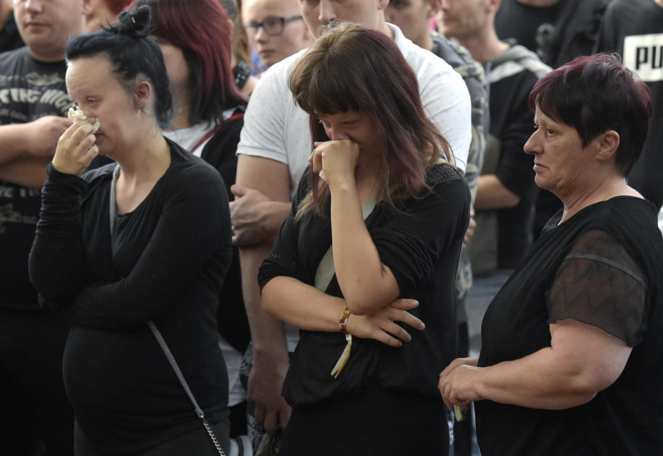 Women cry as people gather at the site of a deadly brawl in Koethen, 90 miles southwest of the German capital Berlin, Sunday, Sept. 9, 2018, after police has arrested two Afghan men on suspicion of killing a 22-year-old German man. (AP Photo/Jens Meyer)