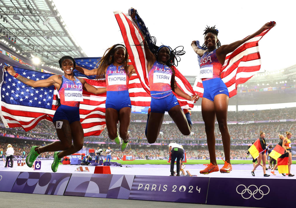 Juegos Olímpicos de París 2024 - Atletismo - Final de relevos 4 x 100 m femenino - Stade de France, Saint-Denis, Francia - 9 de agosto de 2024. Sha'Carri Richardson de Estados Unidos, Gabrielle Thomas de Estados Unidos, Twanisha Terry de Estados Unidos y Melissa Jefferson de Estados Unidos celebran con sus banderas nacionales después de ganar el oro REUTERS/Kai Pfaffenbach