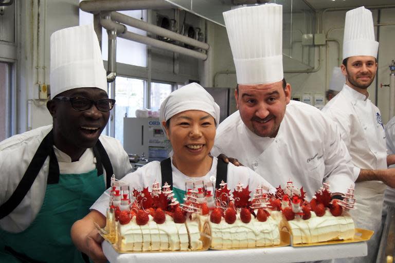 French chef Christoph Paucod (2nd R) and members of his French chef team 'Caravan bon appetit' with a cake they have prepared at an elementary school in Koriyama, on December 9, 2013