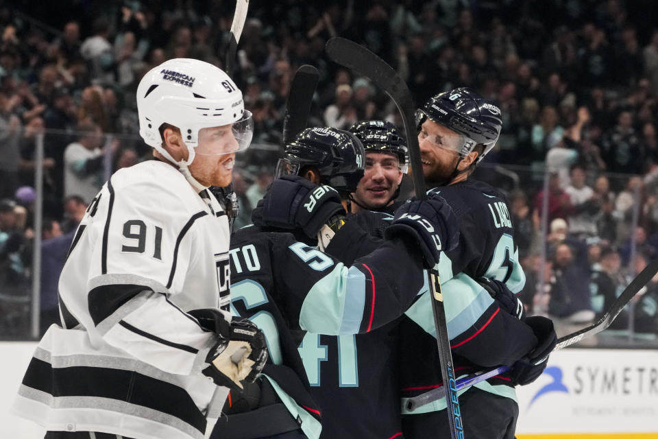 Seattle Kraken defenseman Adam Larsson, right, celebrates his goal with teammates, including Vince Dunn, facing, as Los Angeles Kings right wing Carl Grundstrom (91) skates away during the first period of an NHL hockey game Saturday, Dec. 16, 2023, in Seattle. (AP Photo/Lindsey Wasson)